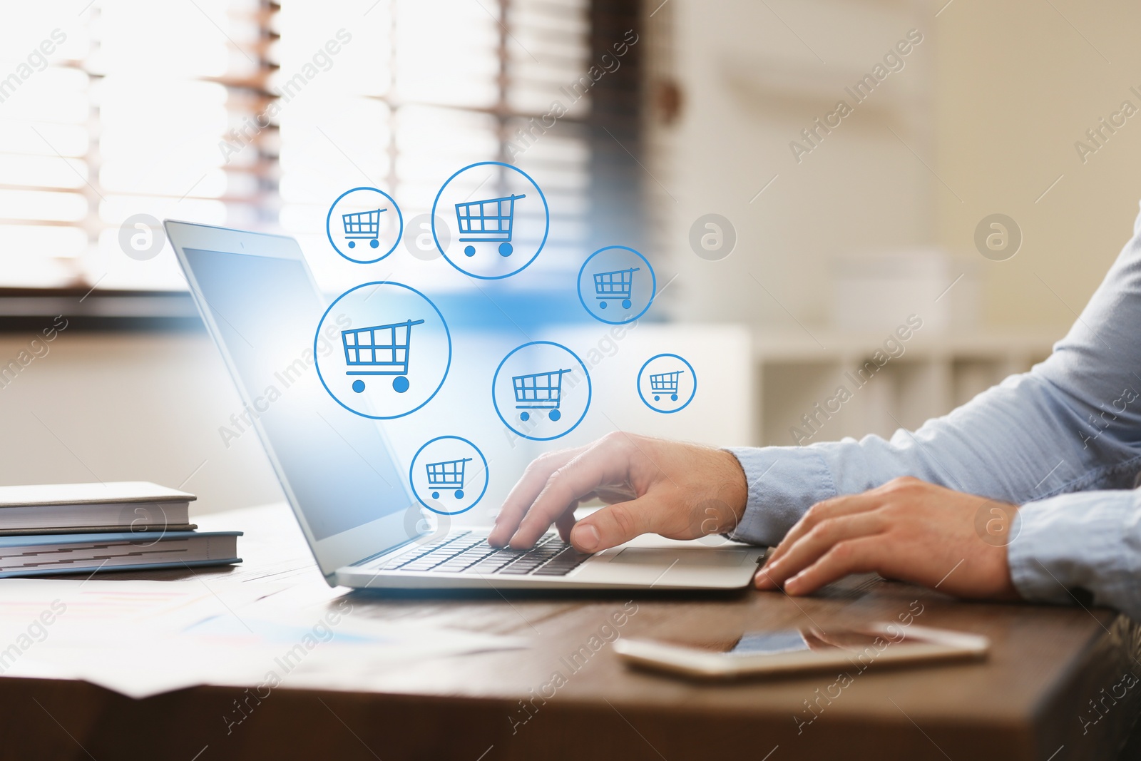 Image of Man using laptop for online shopping at wooden table, closeup