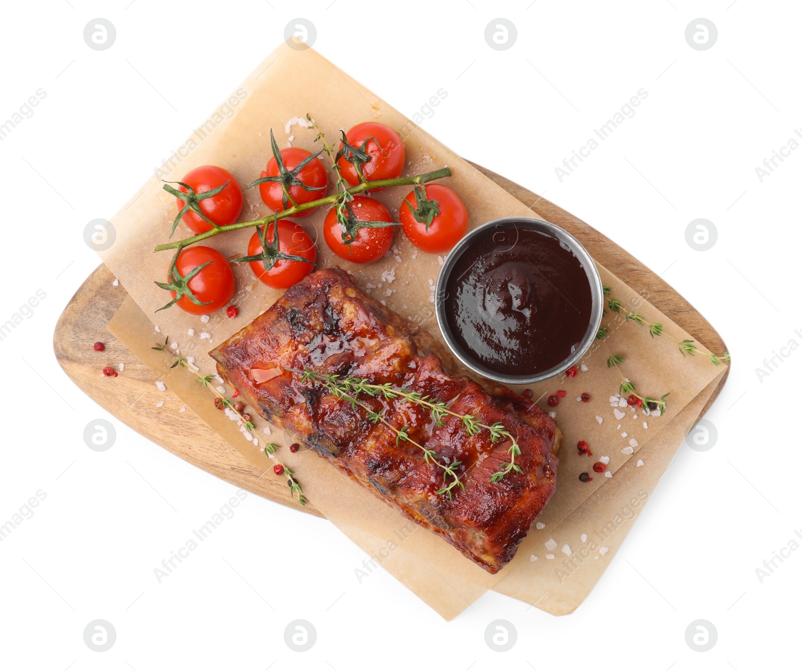 Photo of Tasty roasted pork ribs, thyme, sauce and tomatoes isolated on white, top view