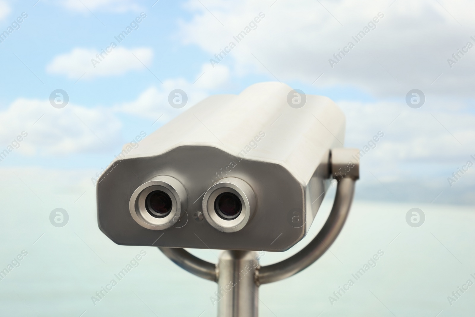 Photo of Metal tower viewer installed near sea. Mounted binoculars