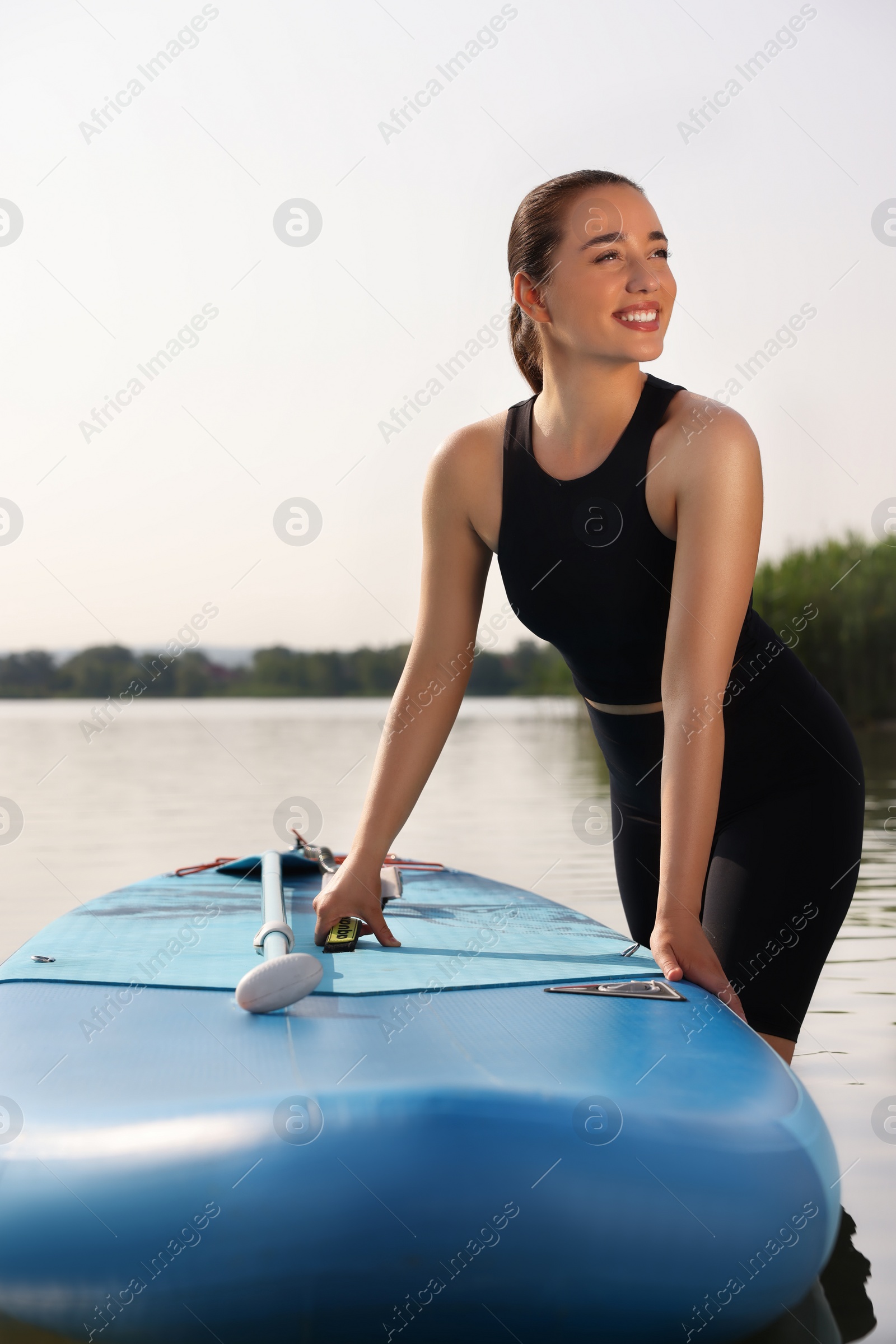 Photo of Woman standing near SUP board in water