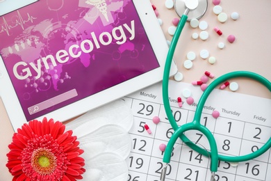 Photo of Flat lay composition with stethoscope, tablet and calendar on color background. Gynecological checkup