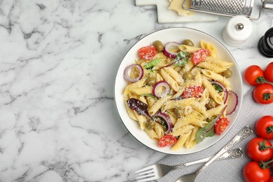 Photo of Bowl of delicious pasta with tomatoes, olives and onion on white marble table, flat lay. Space for text