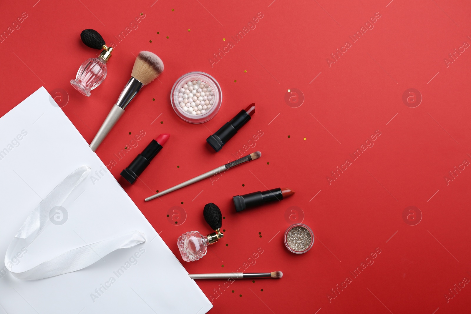 Photo of Flat lay composition with cosmetics and space for text on red background
