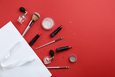 Flat lay composition with cosmetics and space for text on red background