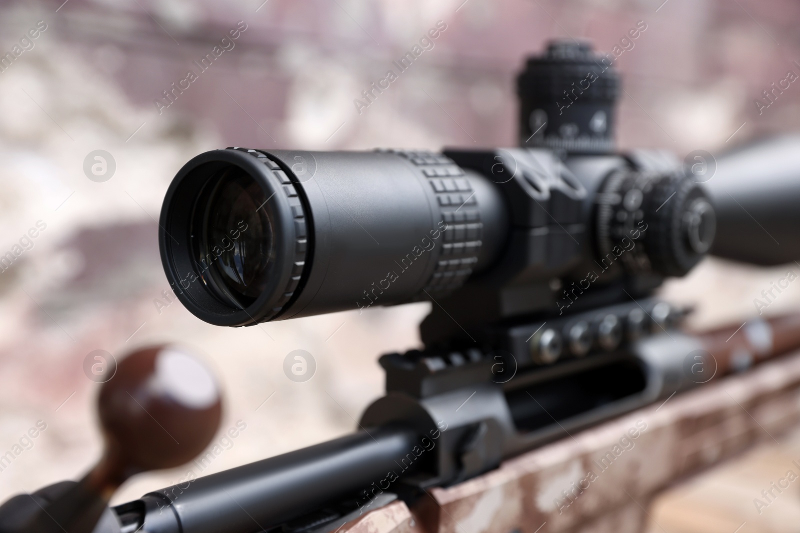 Photo of Closeup view of modern powerful sniper rifle with telescopic sight on blurred background