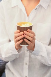 Photo of Woman holding takeaway paper cup, closeup. Coffee to go
