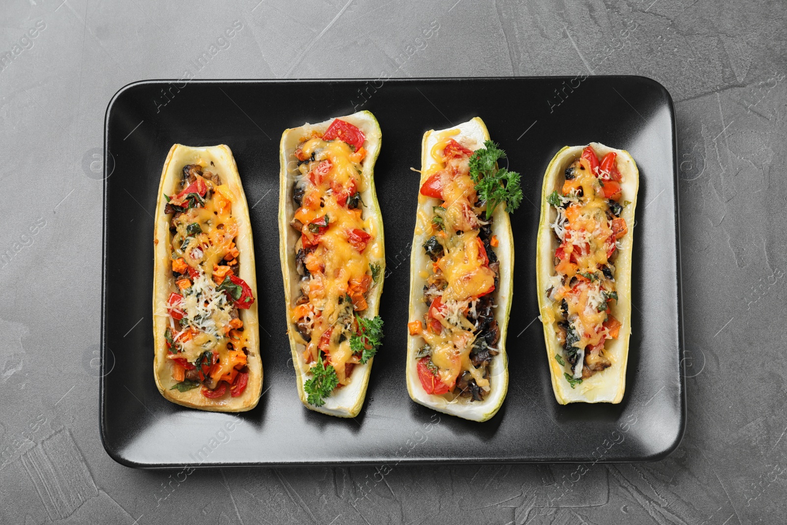 Photo of Delicious stuffed zucchini on grey table, top view