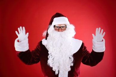 Photo of Portrait of Santa Claus with glasses on red background