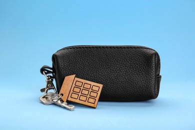 Photo of Leather case with keys on light blue background
