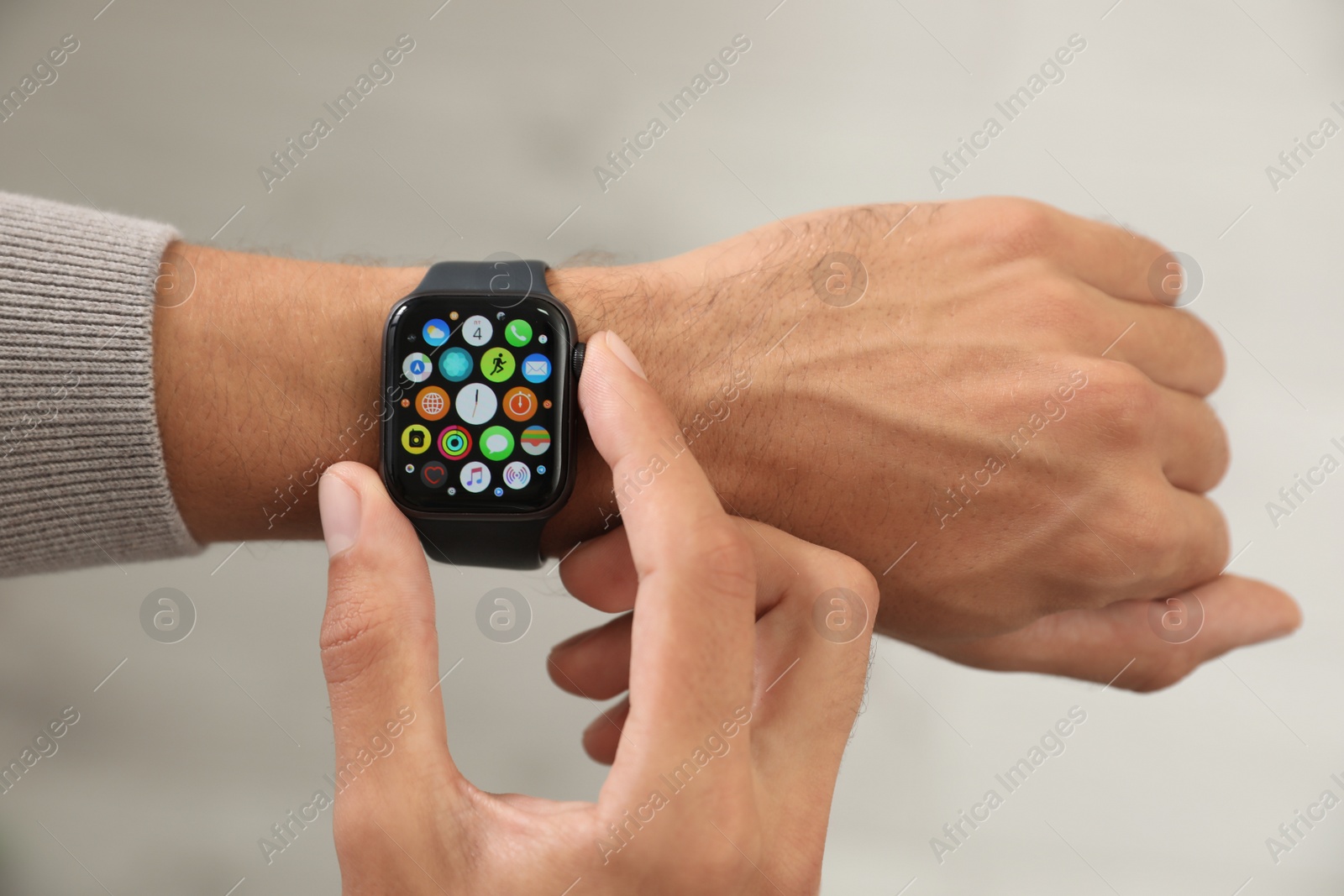 Image of MYKOLAIV, UKRAINE - OCTOBER 04, 2019: Man using Apple Watch on light background. closeup