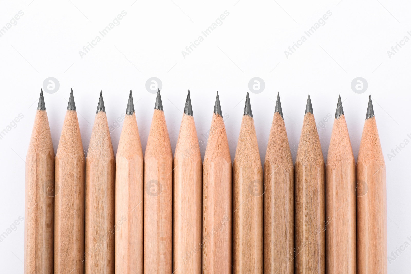 Photo of Many sharp graphite pencils on white background, top view