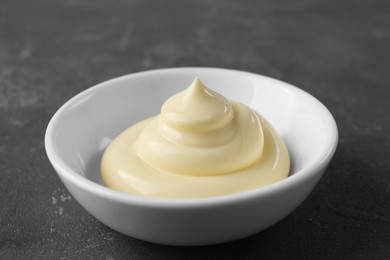 Fresh mayonnaise sauce in bowl on grey table, closeup