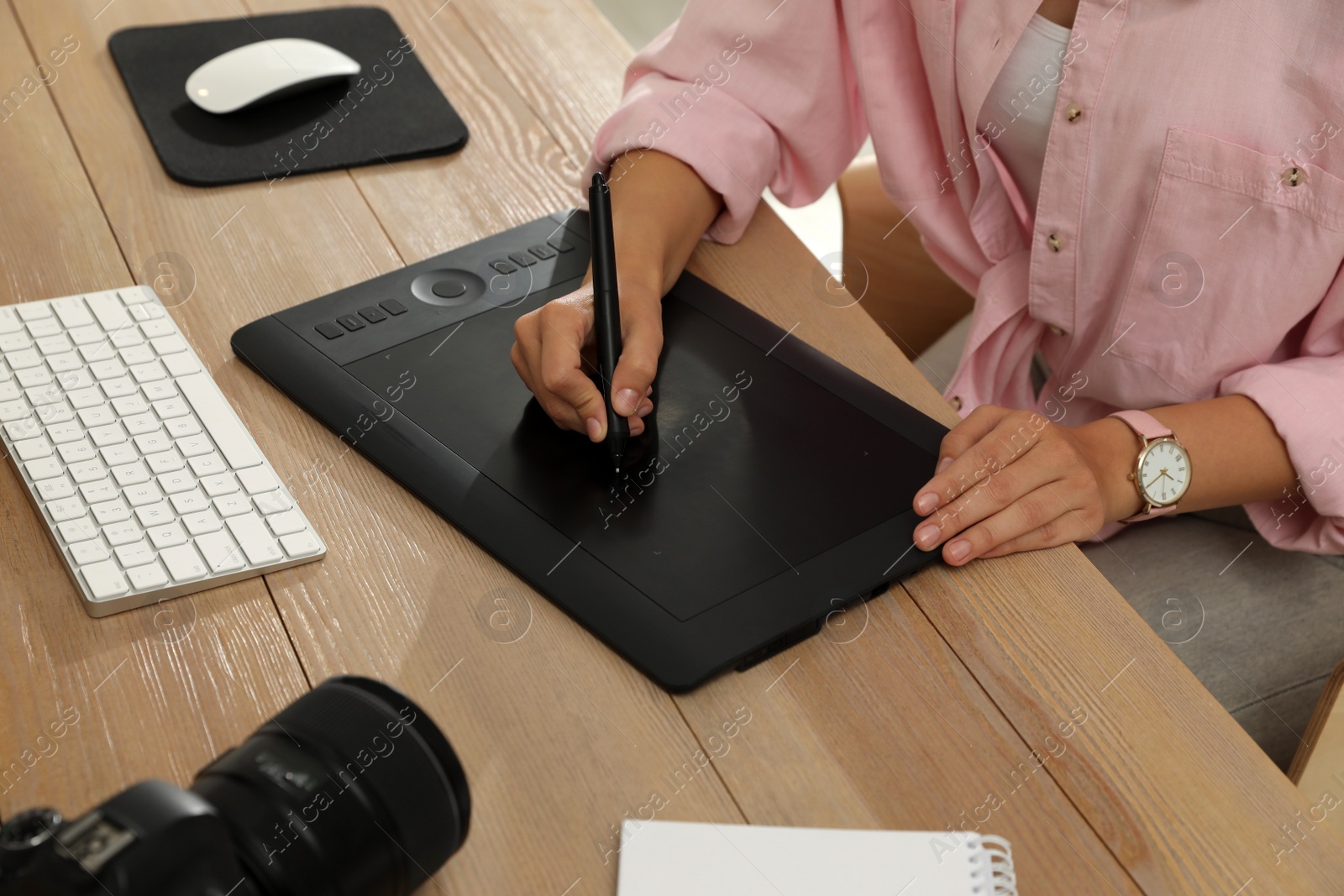 Photo of Professional retoucher working on graphic tablet at desk, closeup