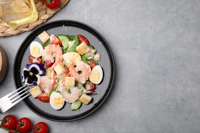 Photo of Delicious Caesar salad with shrimps served on grey table, flat lay. Space for text