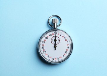 Vintage timer on light blue background, top view