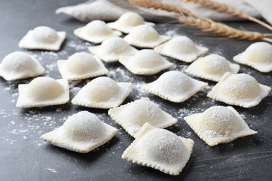Photo of Homemade uncooked ravioli on grey table, closeup