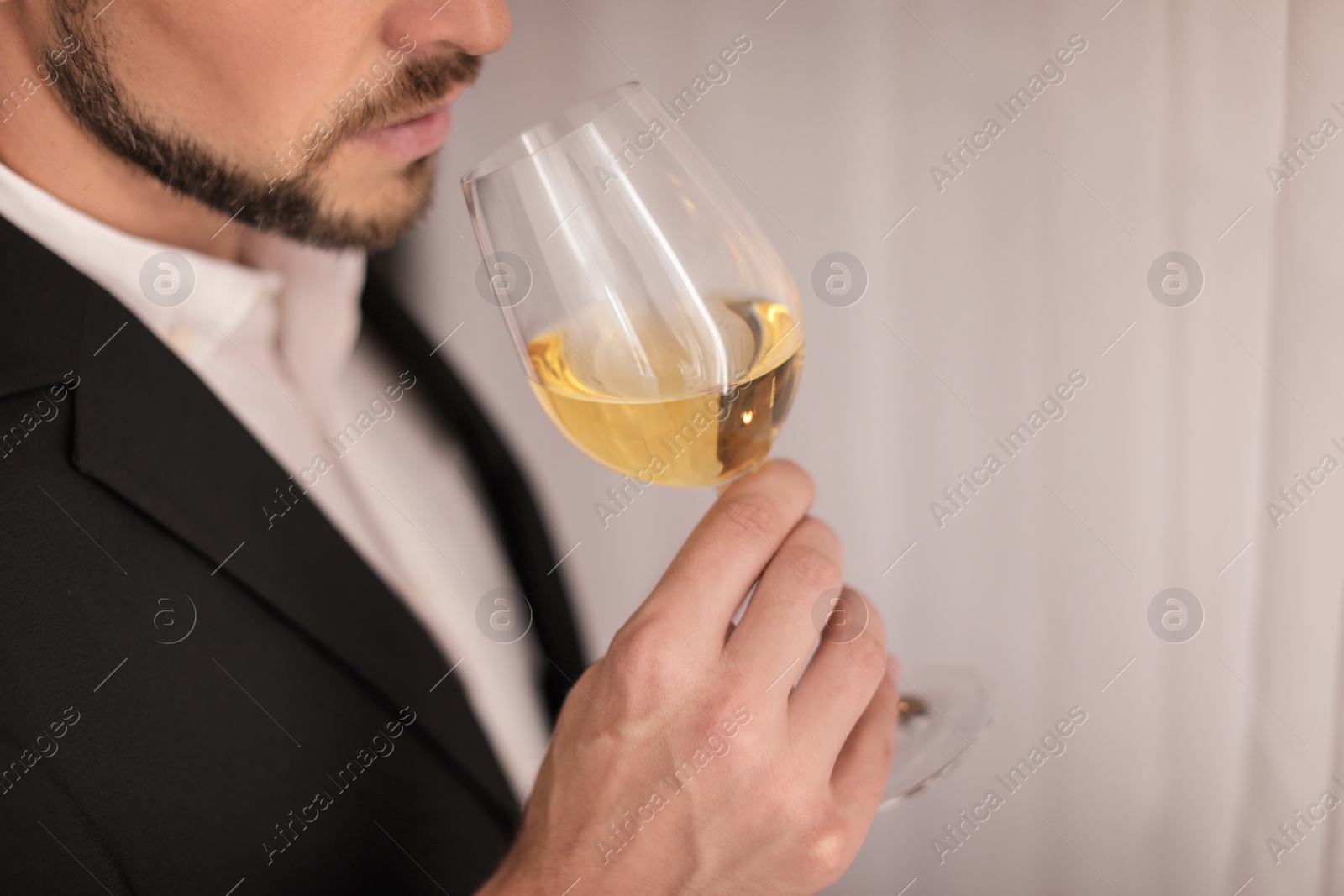 Photo of Young man with glass of wine indoors