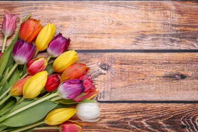 Photo of Beautiful colorful tulip flowers on wooden table, flat lay. Space for text