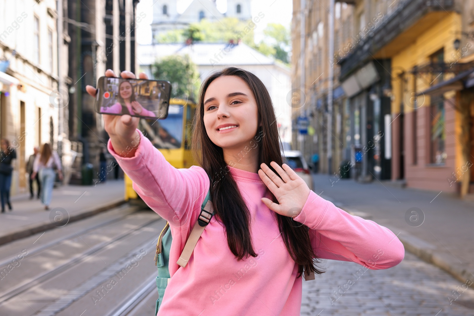 Photo of Travel blogger with smartphone streaming on city street