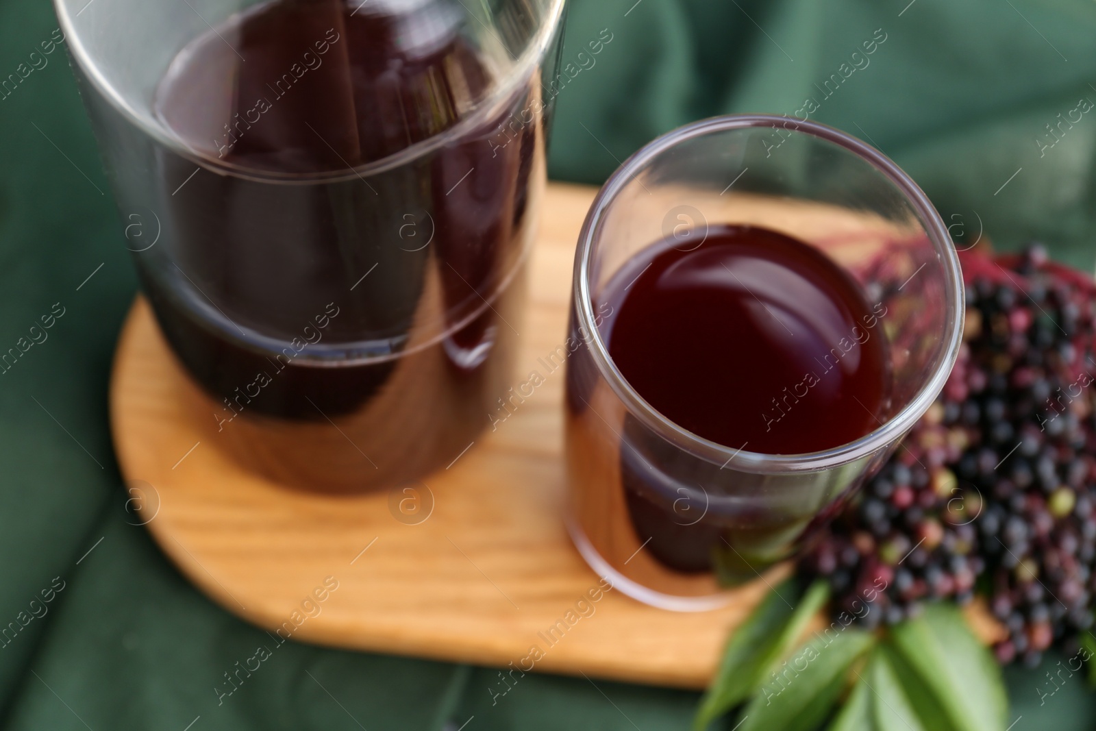 Photo of Elderberry drink and Sambucus berries on table, closeup