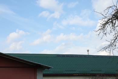 House with green roof under cloudy sky outdoors