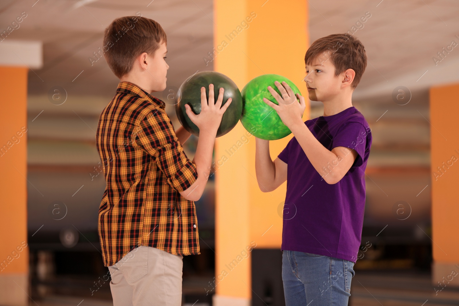 Photo of Happy boys with balls in bowling club