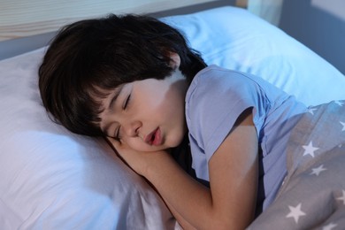 Photo of Cute little boy sleeping in bed at home