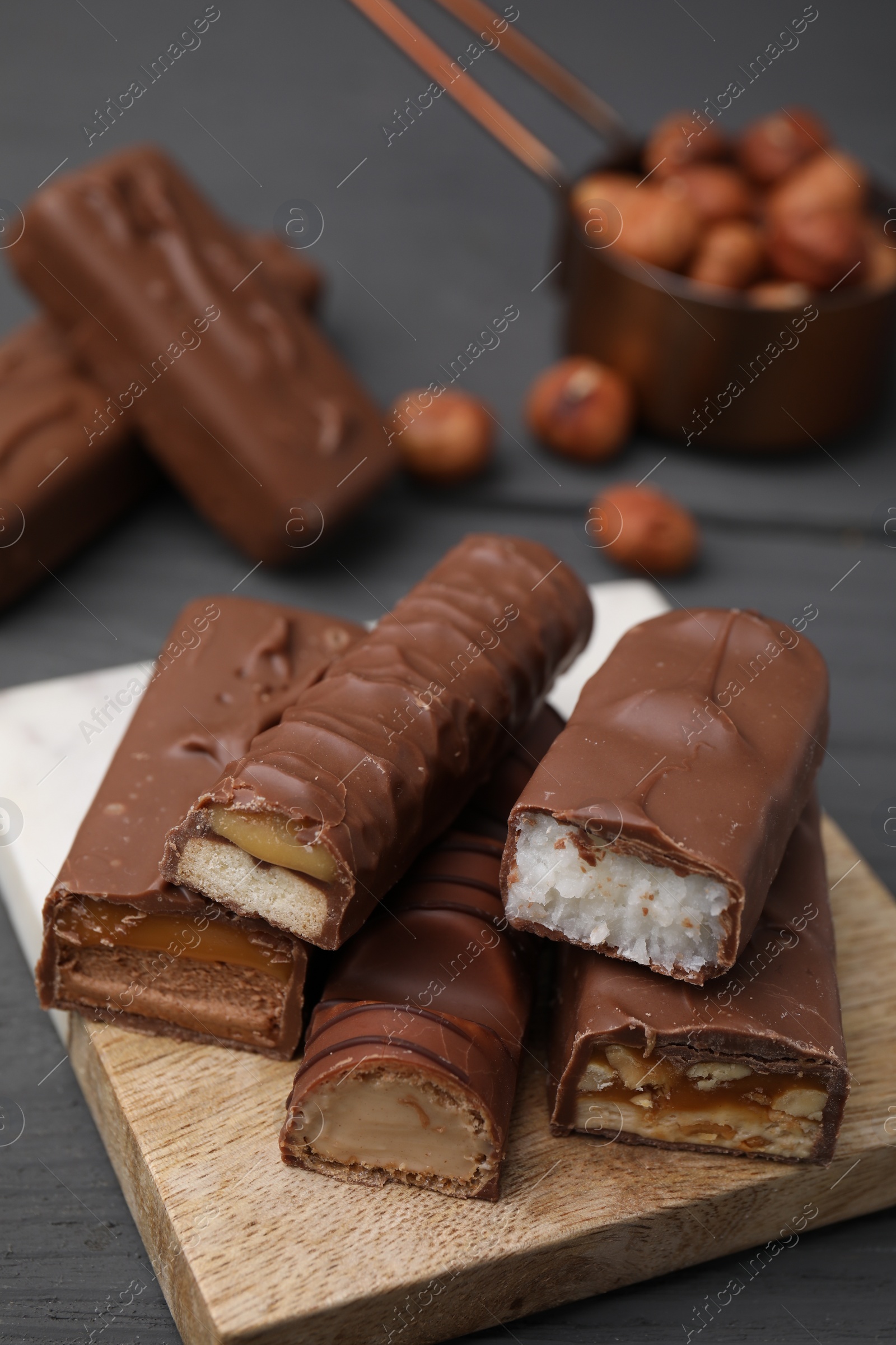 Photo of Pieces of different tasty chocolate bars on board, closeup