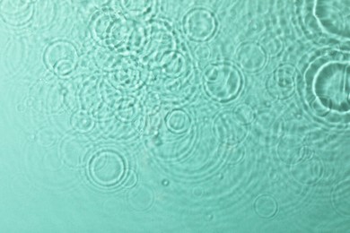 Photo of Clear water with rippled surface on turquoise background, top view