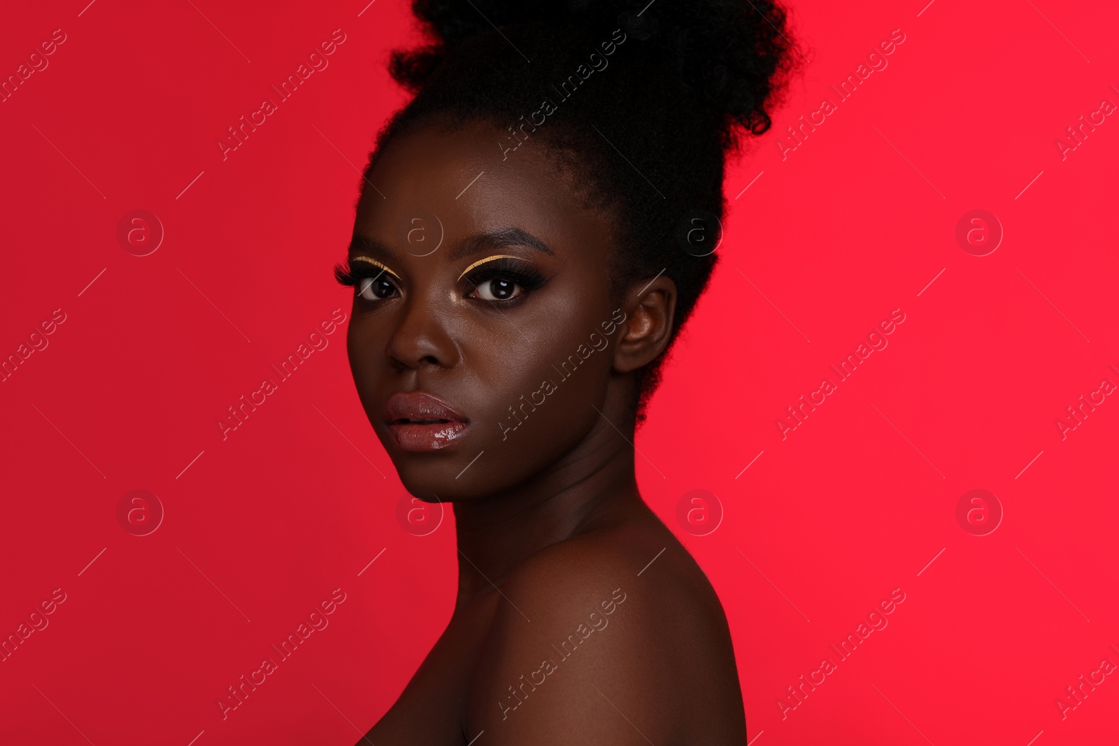 Photo of Fashionable portrait of beautiful woman with bright makeup on coral background