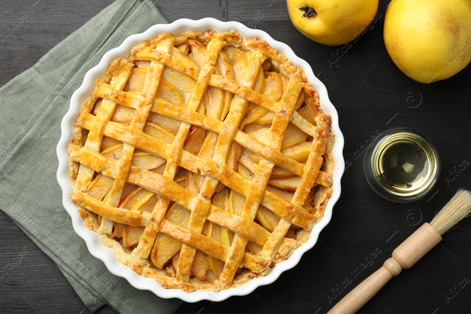 Photo of Tasty homemade quince pie and fresh fruits on black wooden table, flat lay