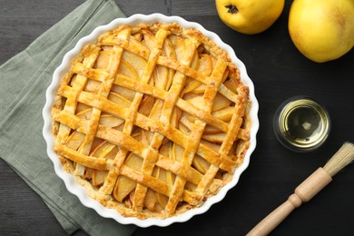 Photo of Tasty homemade quince pie and fresh fruits on black wooden table, flat lay