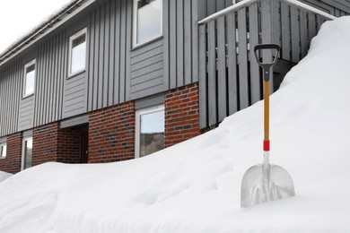 Snow cleaning shovel near house. Winter outdoor work