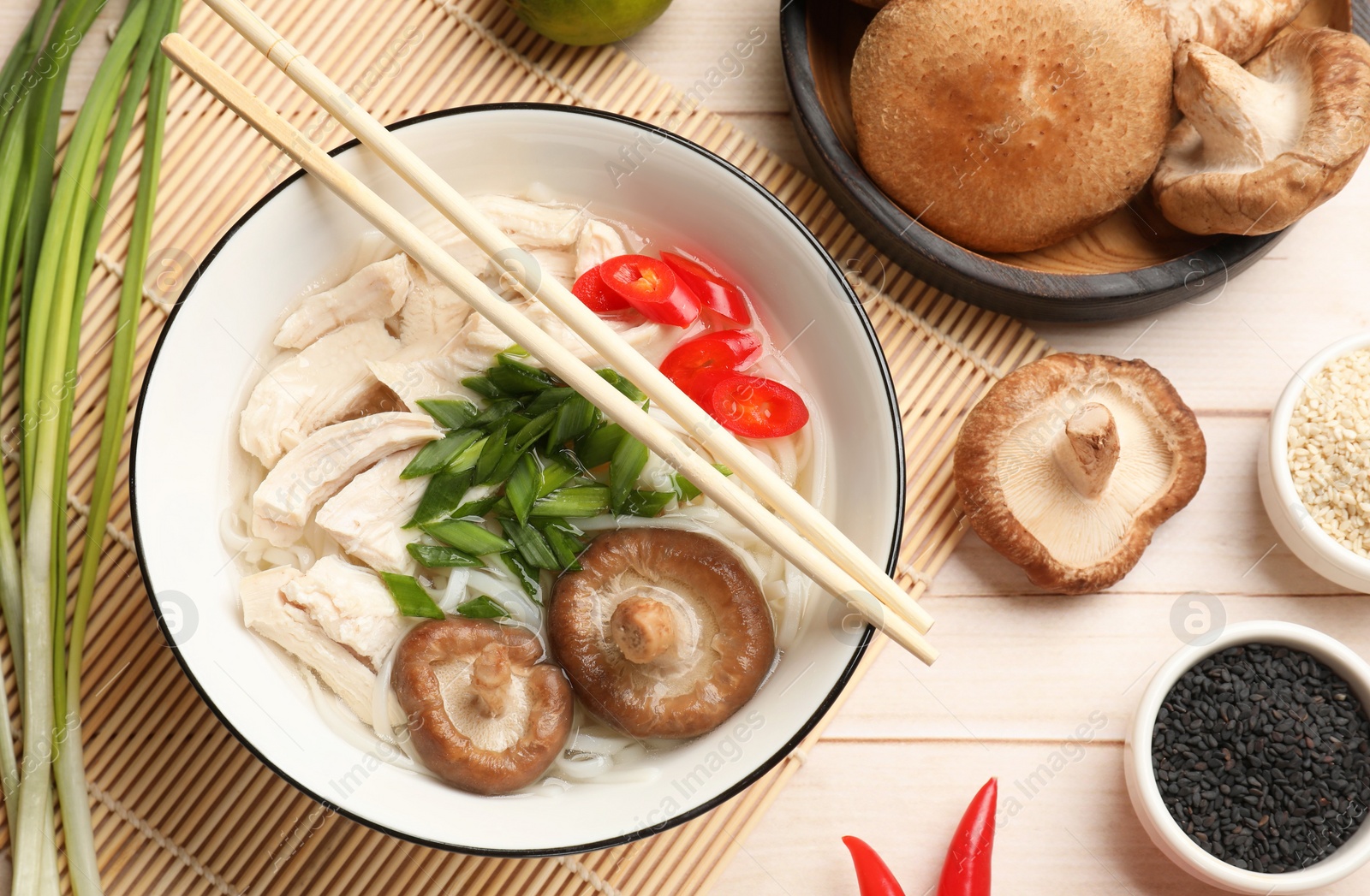 Photo of Delicious ramen with meat and ingredients on wooden table, flat lay. Noodle soup