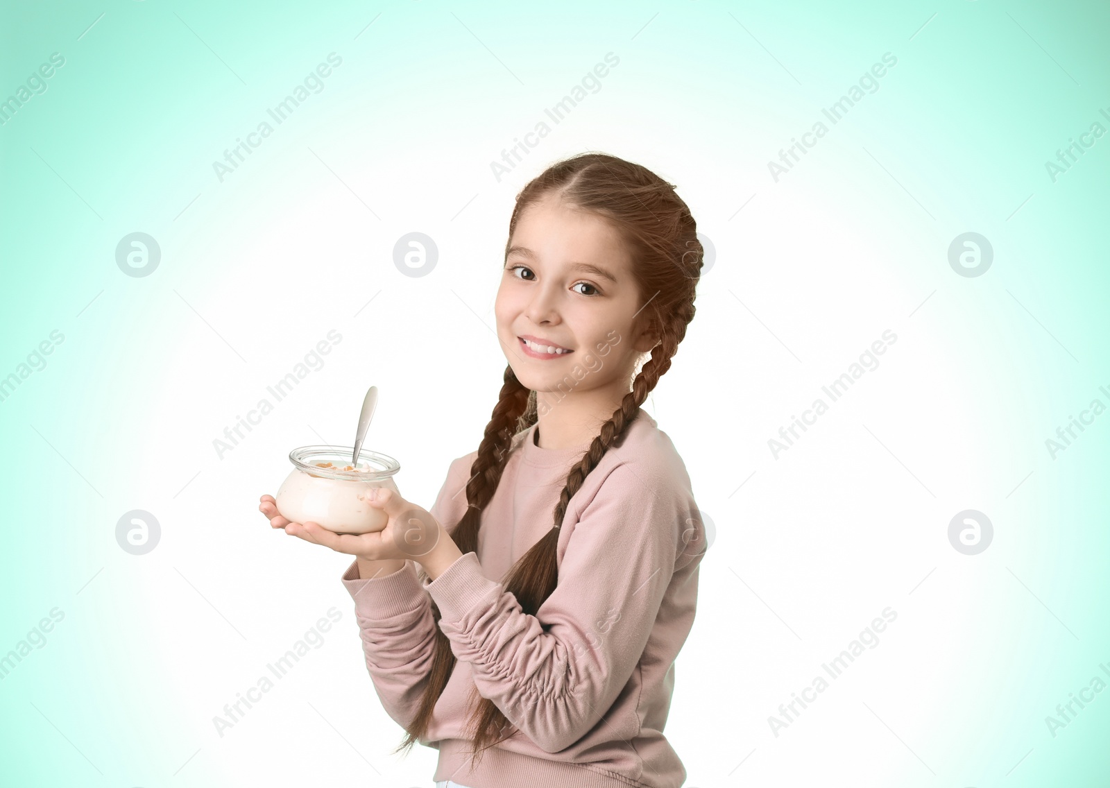 Photo of Cute girl eating tasty yogurt on color background