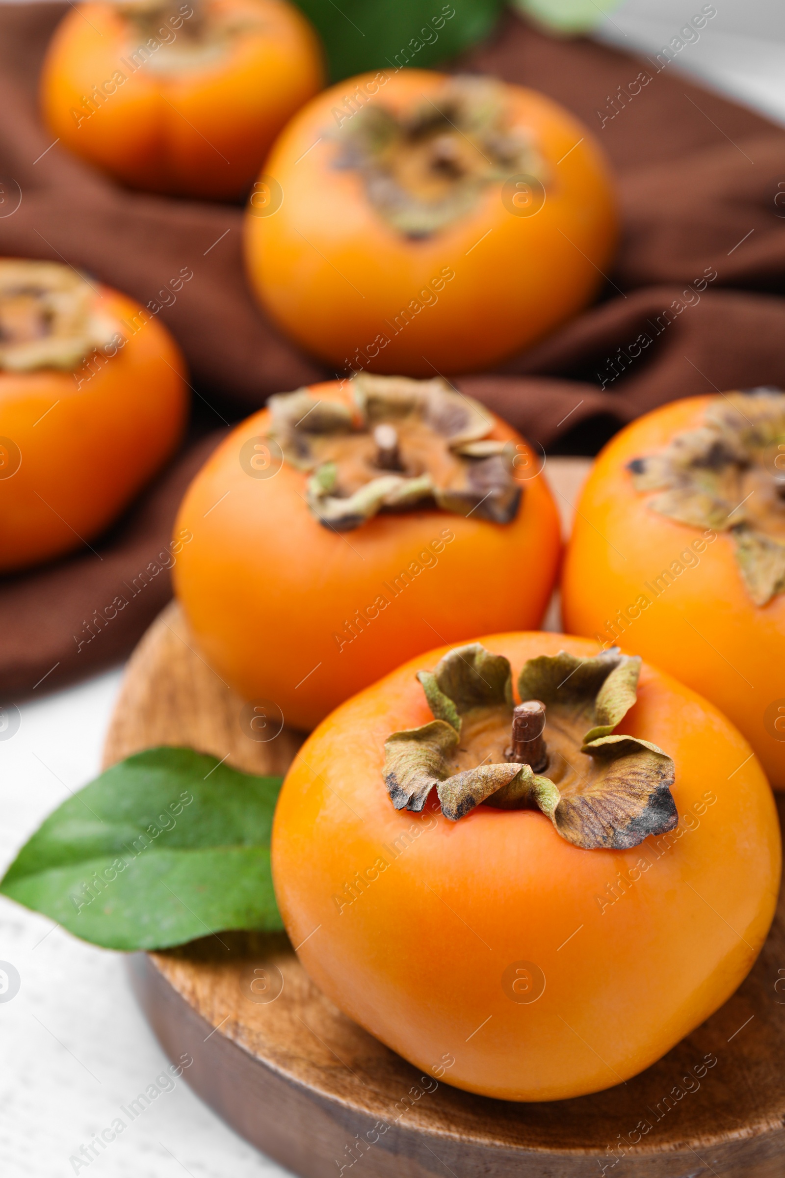 Photo of Delicious ripe juicy persimmons on table, closeup