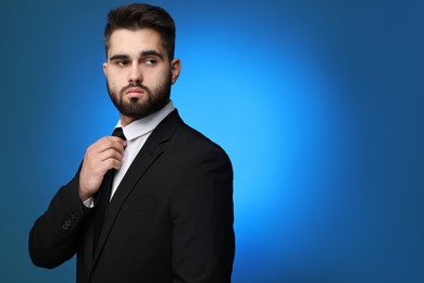 Photo of Handsome businessman in suit and necktie on blue background. Space for text