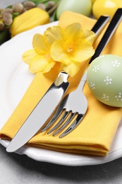 Festive Easter table setting with eggs on grey background, closeup