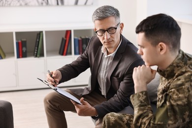 Professional psychotherapist working with military man in office