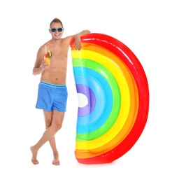 Photo of Shirtless man with inflatable mattress and glass of cocktail on white background