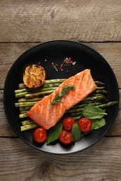 Photo of Tasty grilled salmon with tomatoes, asparagus and spices on wooden table, top view