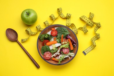 Photo of Measuring tape, vegetable salad and apple on yellow background, flat lay. Weight loss concept