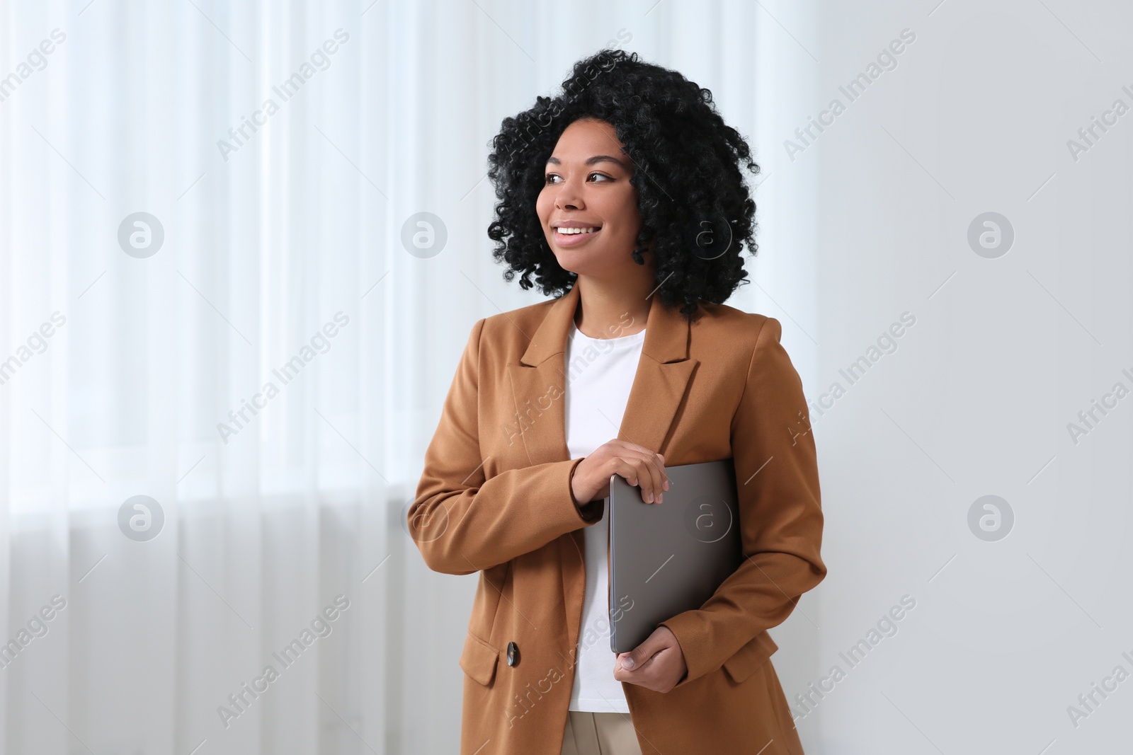 Photo of Smiling young businesswoman with laptop in office