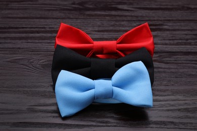 Photo of Different stylish bow ties on wooden table