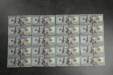 Photo of Money exchange. Dollar banknotes on dark gray textured background, top view