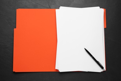 Photo of Orange file with blank sheets of paper and pen on black slate table, top view. Space for design