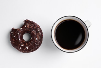 Photo of Tasty donut and cup of coffee on white background, flat lay