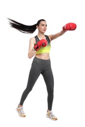 Beautiful woman in boxing gloves training on white background