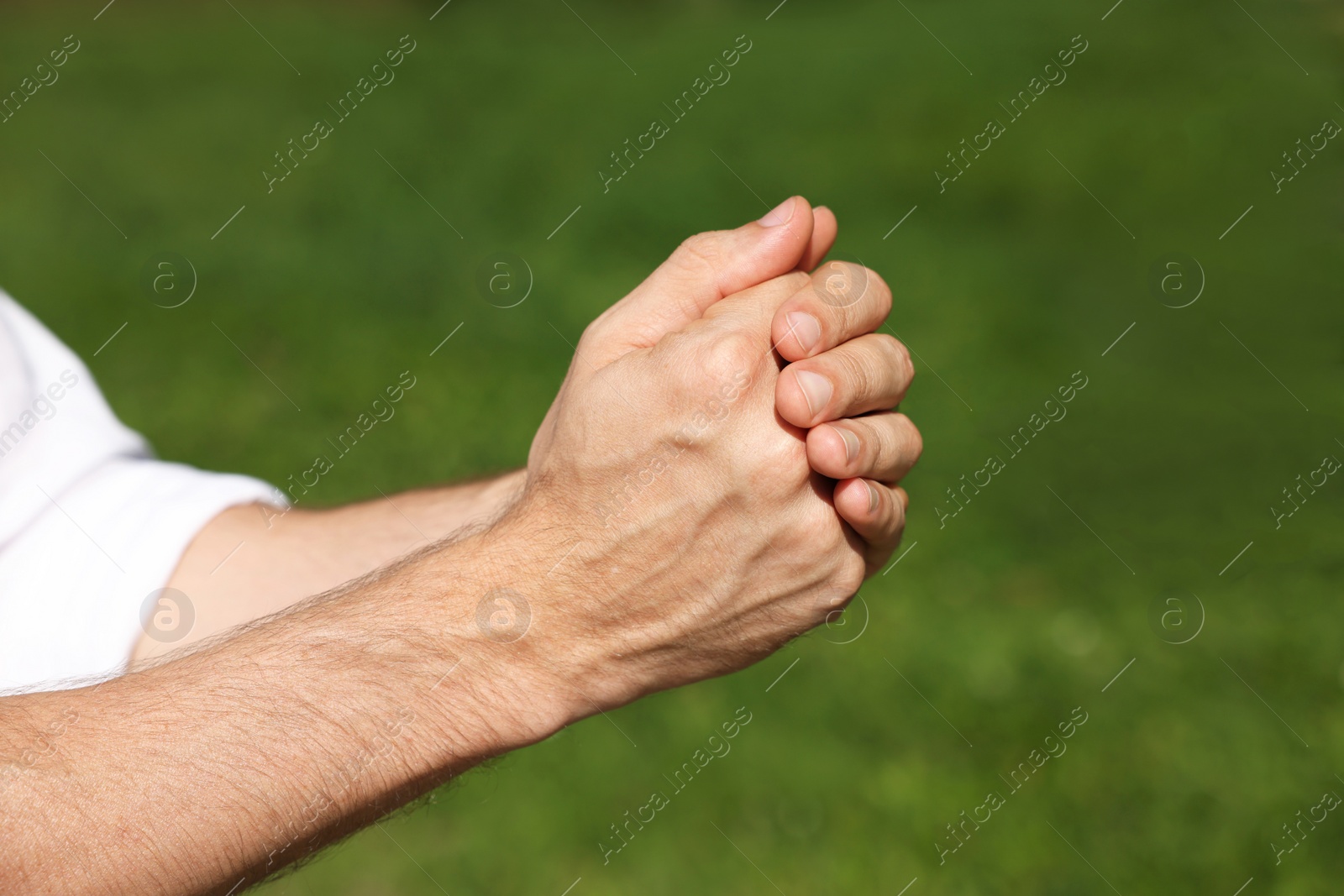 Photo of Man praying outdoors on sunny day, closeup