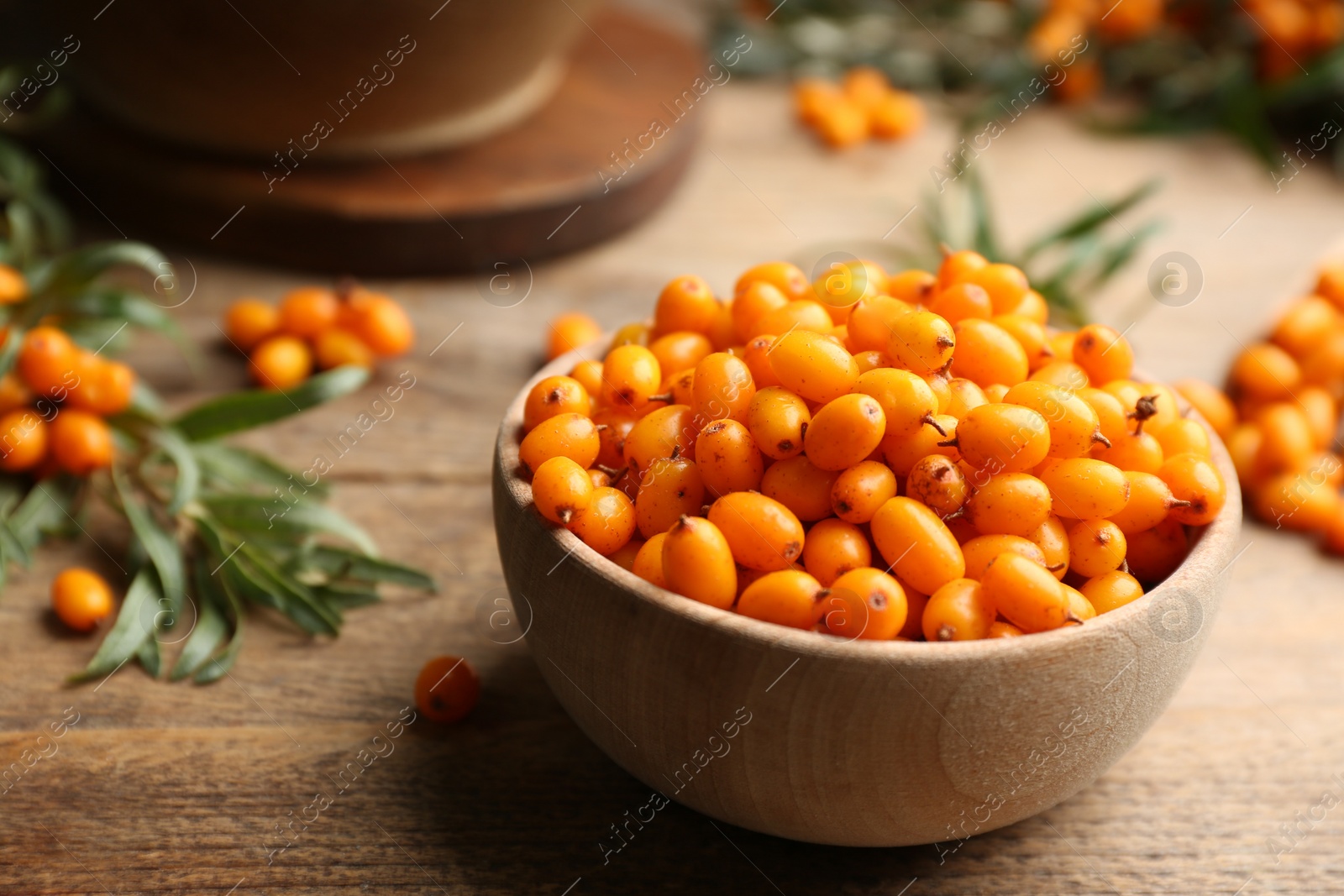 Photo of Ripe sea buckthorn berries on wooden table, closeup